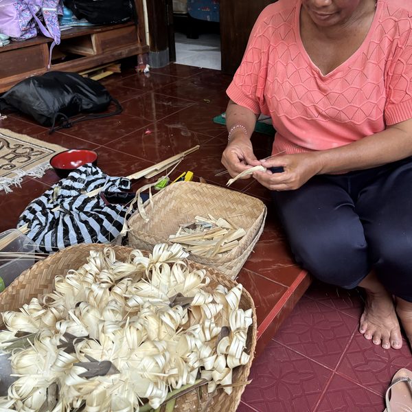 Balinese woman weaving palm leaf offerings Ubud